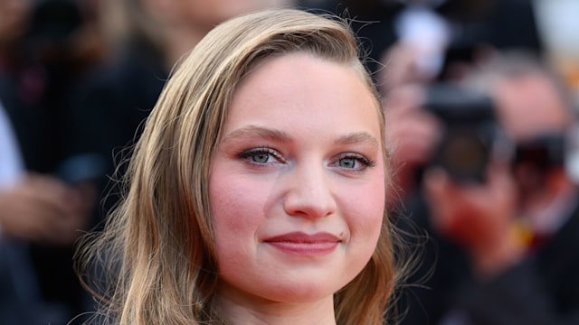 Mia Threapleton waist up in green dress 