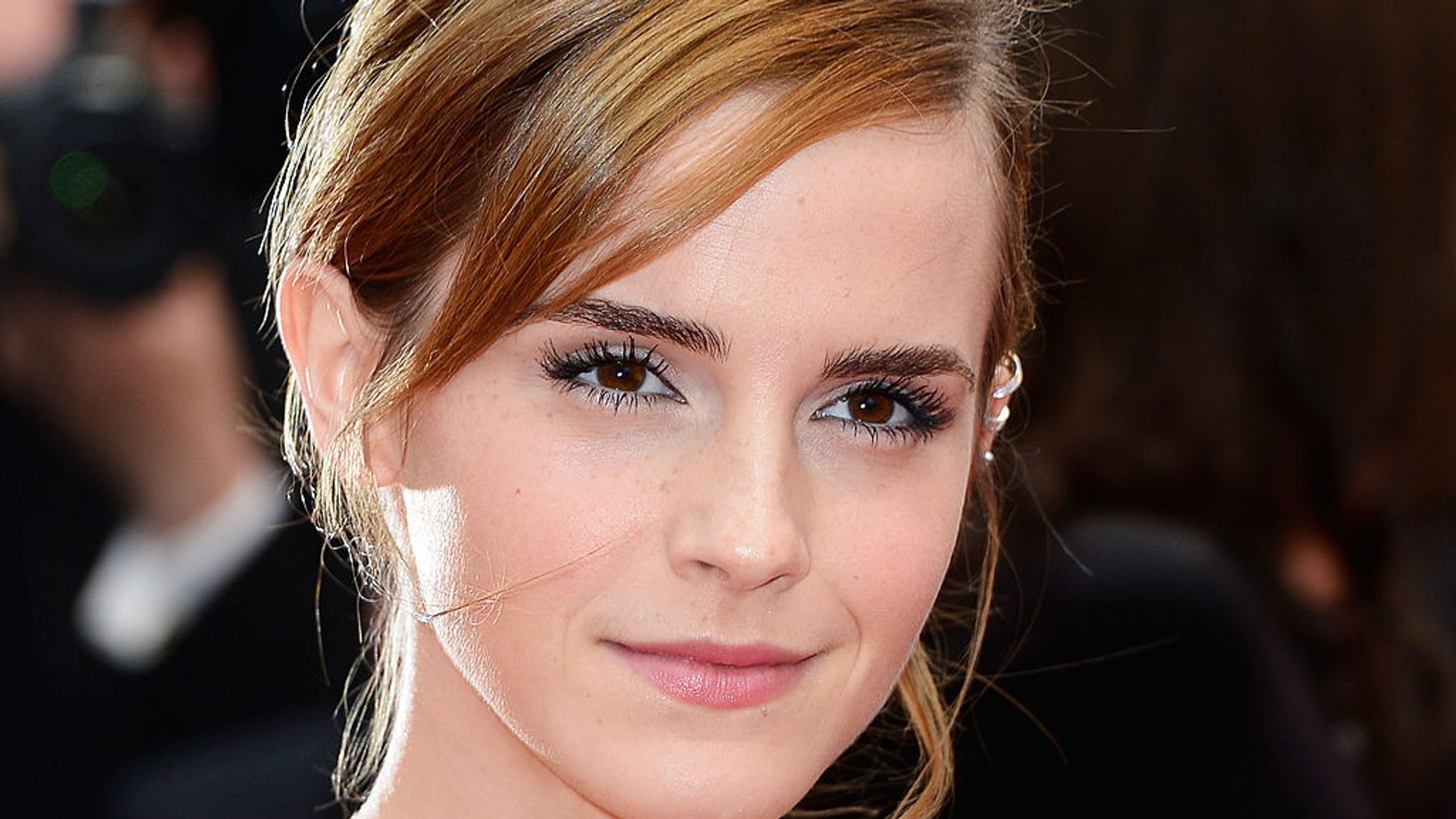 a zoomed in image of emma watson looking straight to camera with golden blonde hair 