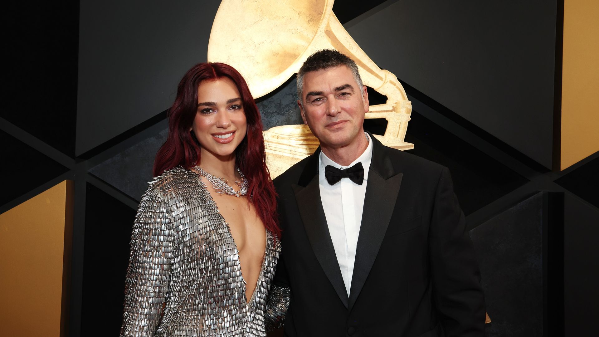 Dua Lipa stuns in a plunging silver gown as she makes rare appearance with dad at Grammys