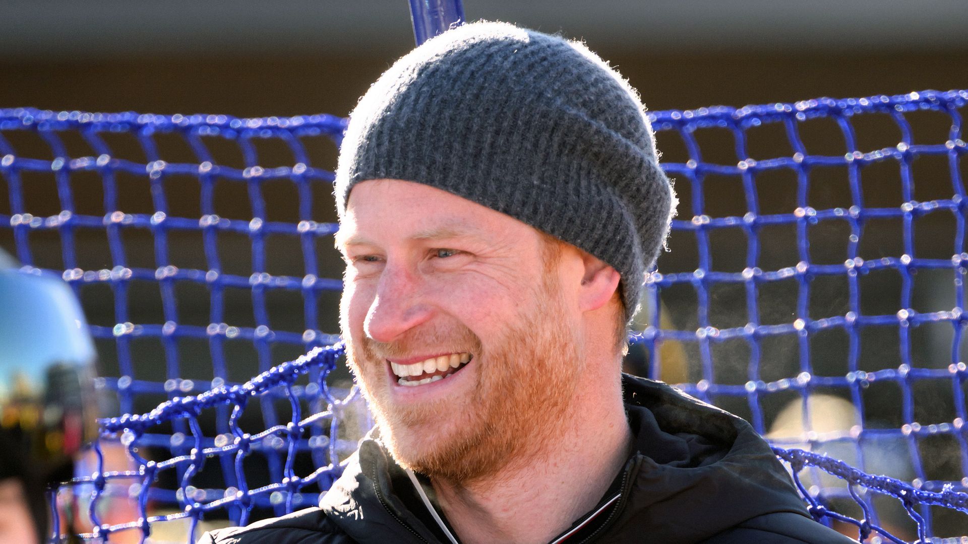 Prince Harry smiling in a wool hat