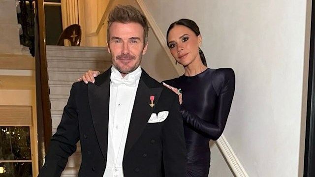 Victoria Beckham and David Beckham posing on the stairs