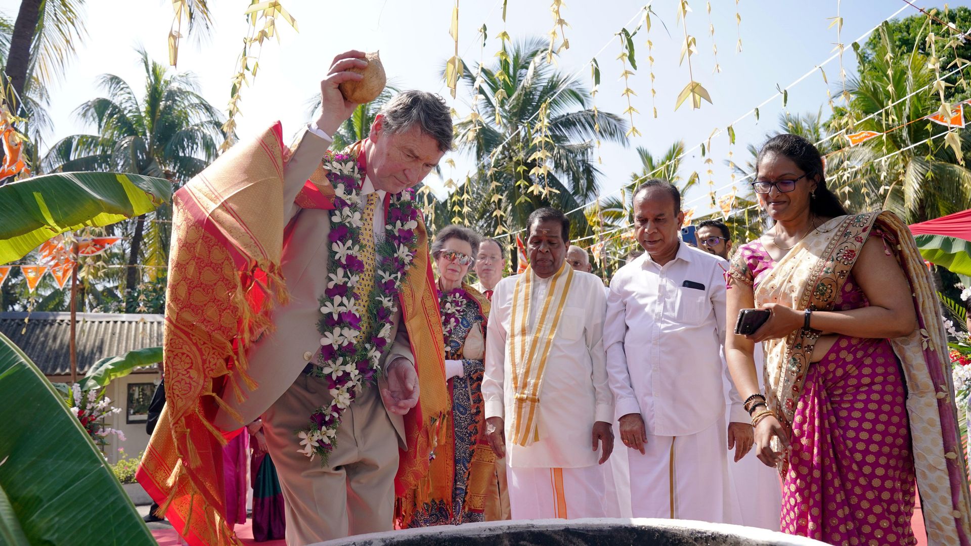 Vice Admiral Sir Timothy Laurence smashes a coconut, a ritual believed to banish bad luck, during a visit to Vajira Pillayar Kovil Hindu temple in Colombo, Sri Lanka