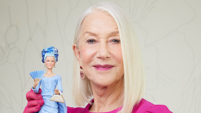 Dame Helen Mirren holding her one-of-a-kind Barbie