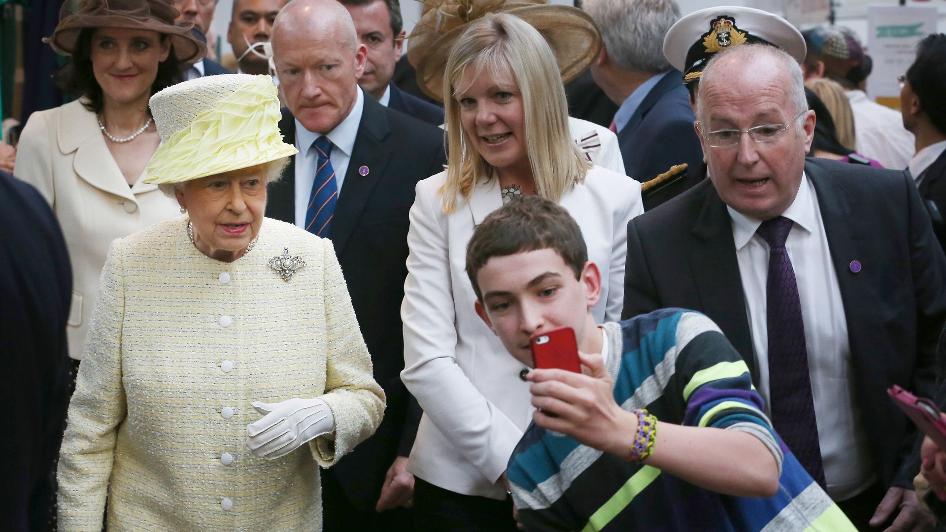 Queen Elizabeth II looking unimpressed as a fan tries to take a selfie with her