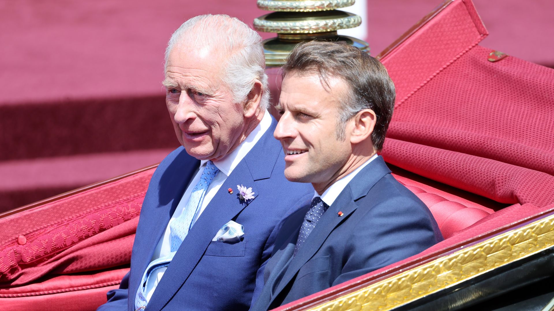 King Charles and Emmanuel Macron riding in a carriage