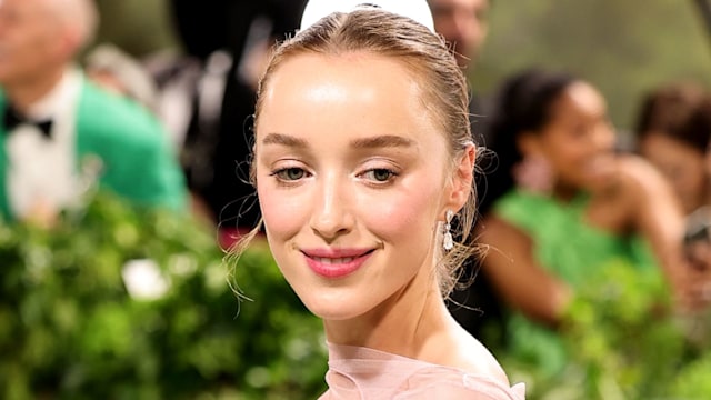 Phoebe Dynevor walks up stairs in pink dress