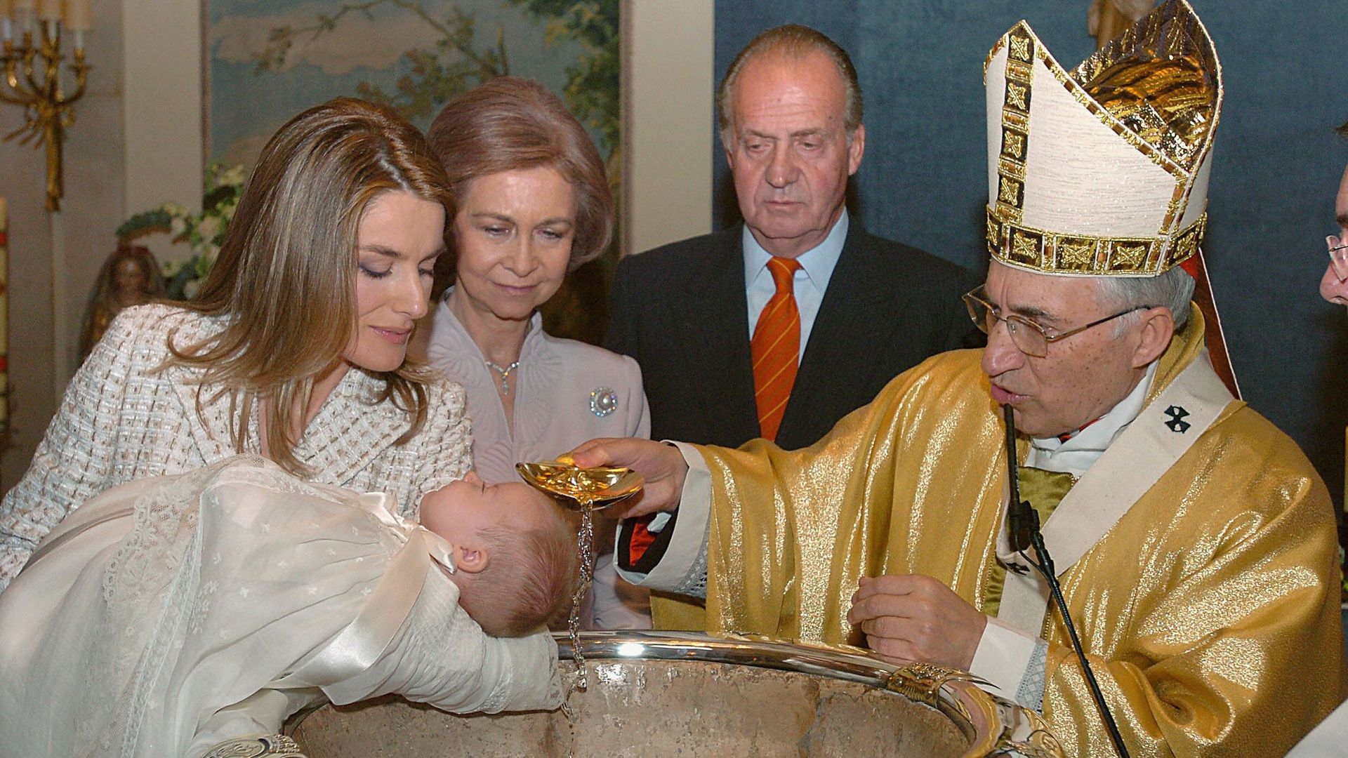 Princess Leonor getting chistened - Queen Letizia holds her while Queen Sofia and King Juan Carlos look on