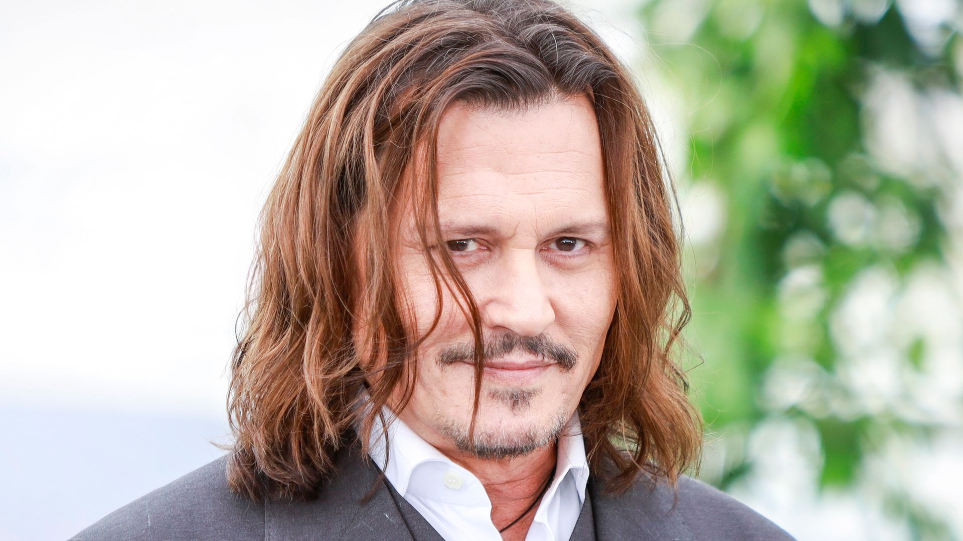 Johnny Depp smirking in a grey suit