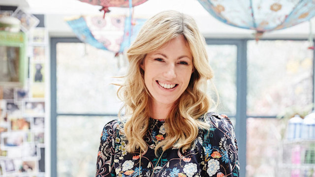 Marina Fogle wearing a floral printed dress sitting on a desk 