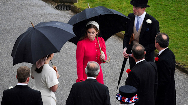 Princess Beatrice wearing red dress and headband at Buckingham Palace Garden Party in the rain