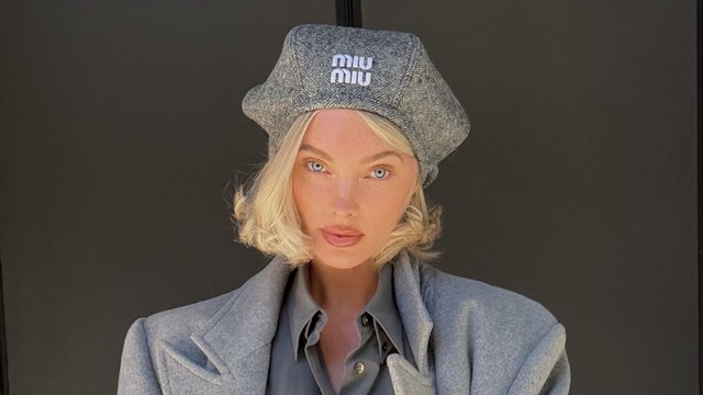 Elsa Hosk poses in a grey coat, beret, shirt and trouser combo