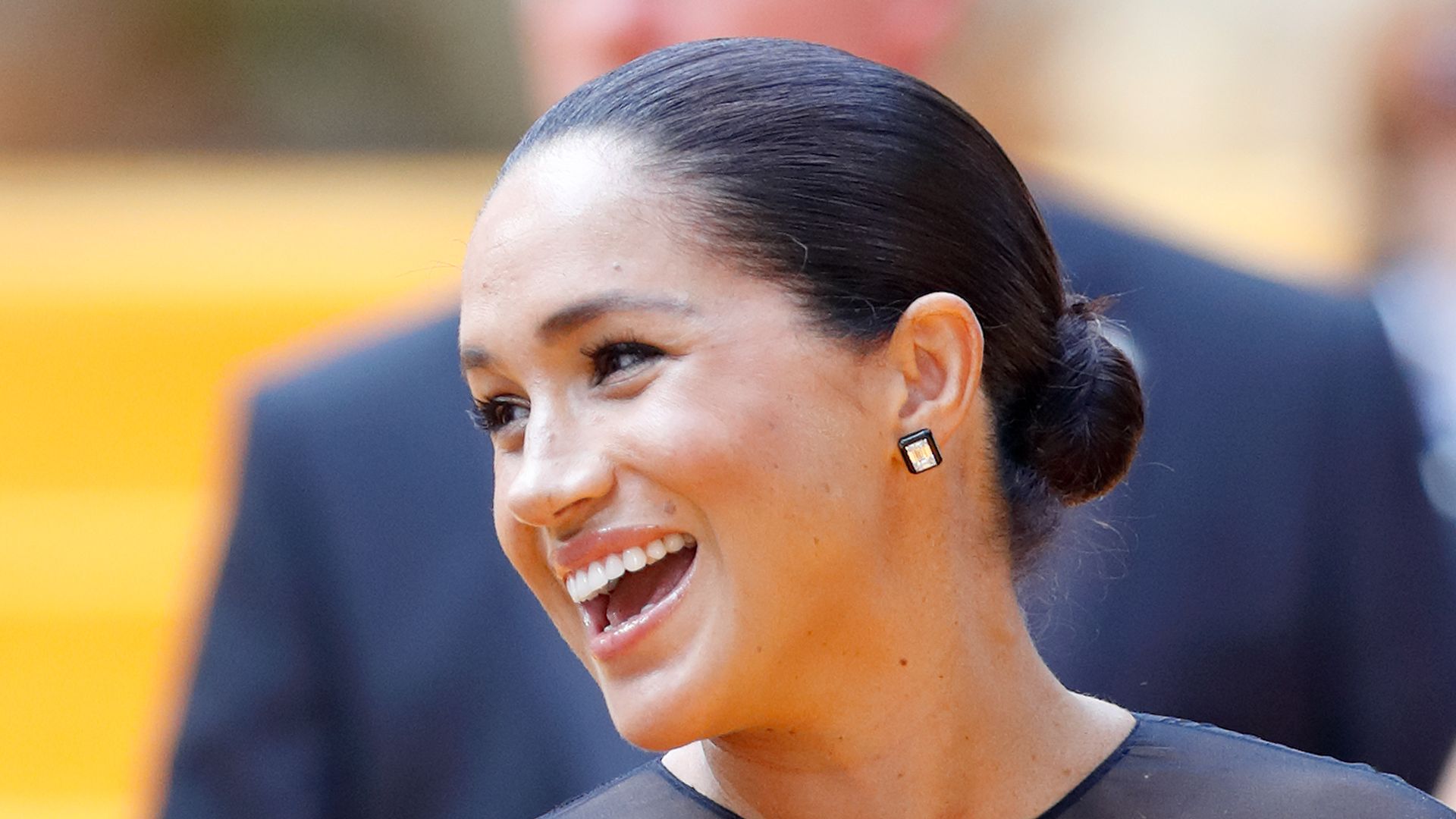 Meghan, Duchess of Sussex smiling with hair in bun