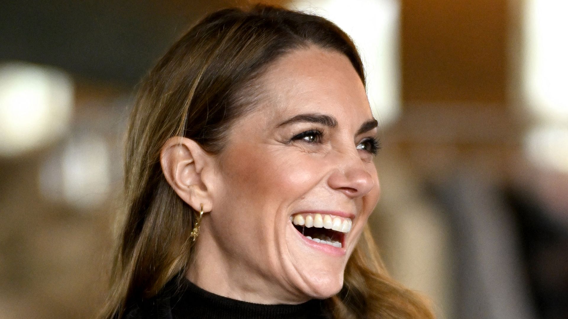 Princess of Wales laughing in cardigan and khaki waxed jacket