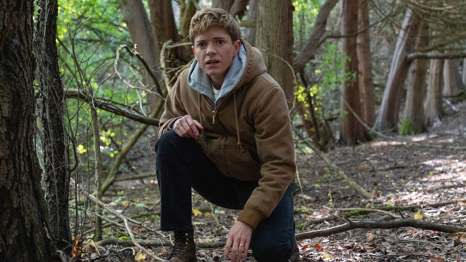 person in woodland area crouching down