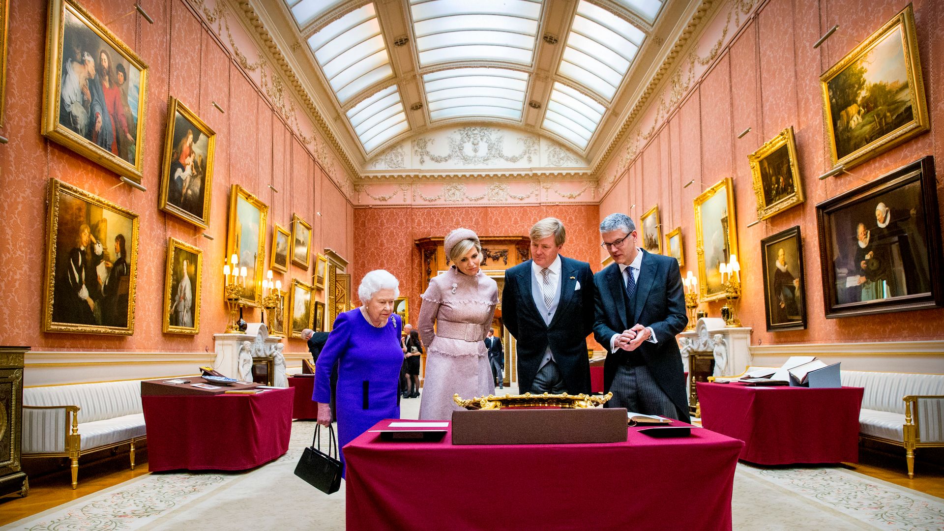 The Queen, Queen Maxima, King Willem-Alexander and a man inspecting art at Buckingham Palace's gallery