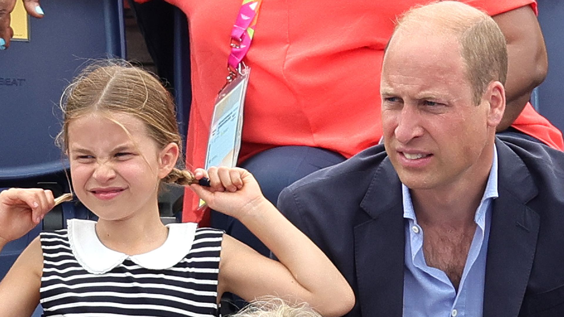 Princess Charlotte pulling her pigtails next to Prince William