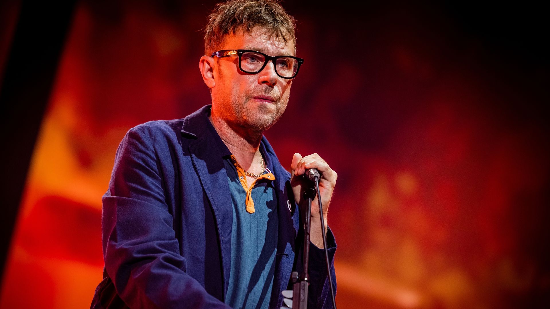 Damon Albarn on stage with Blur in a blue suit