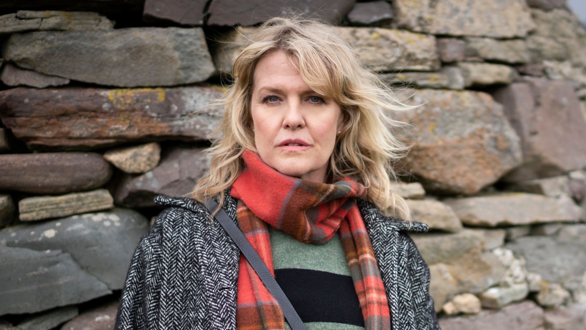 woman standing against wall of rocks