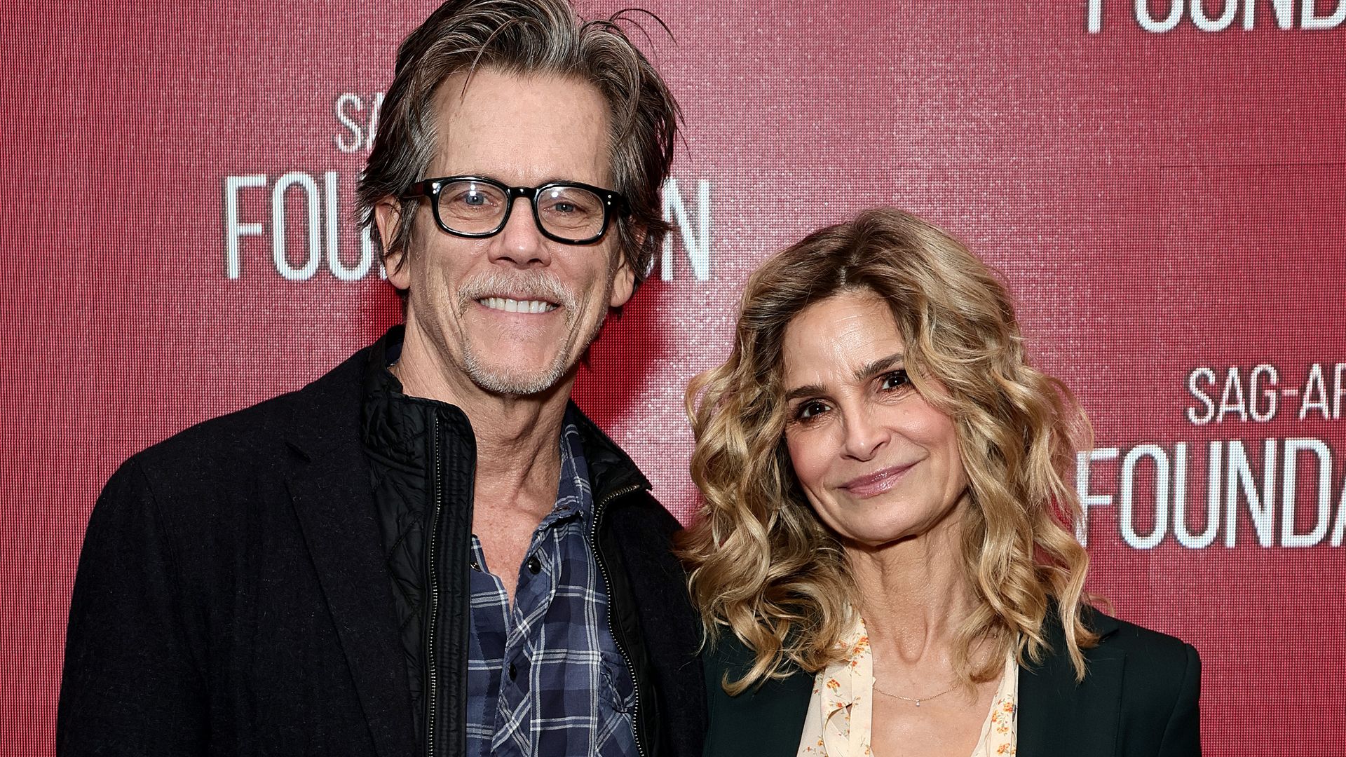 Kyra Sedgwick and Kevin Bacon smiling on a red carpet