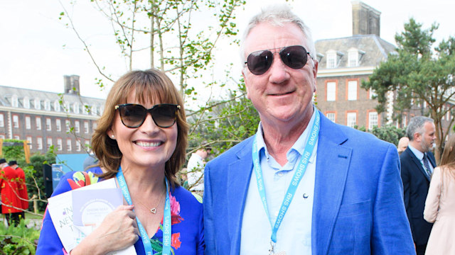 Lorraine Kelly standing with husband Steve - both wear blue