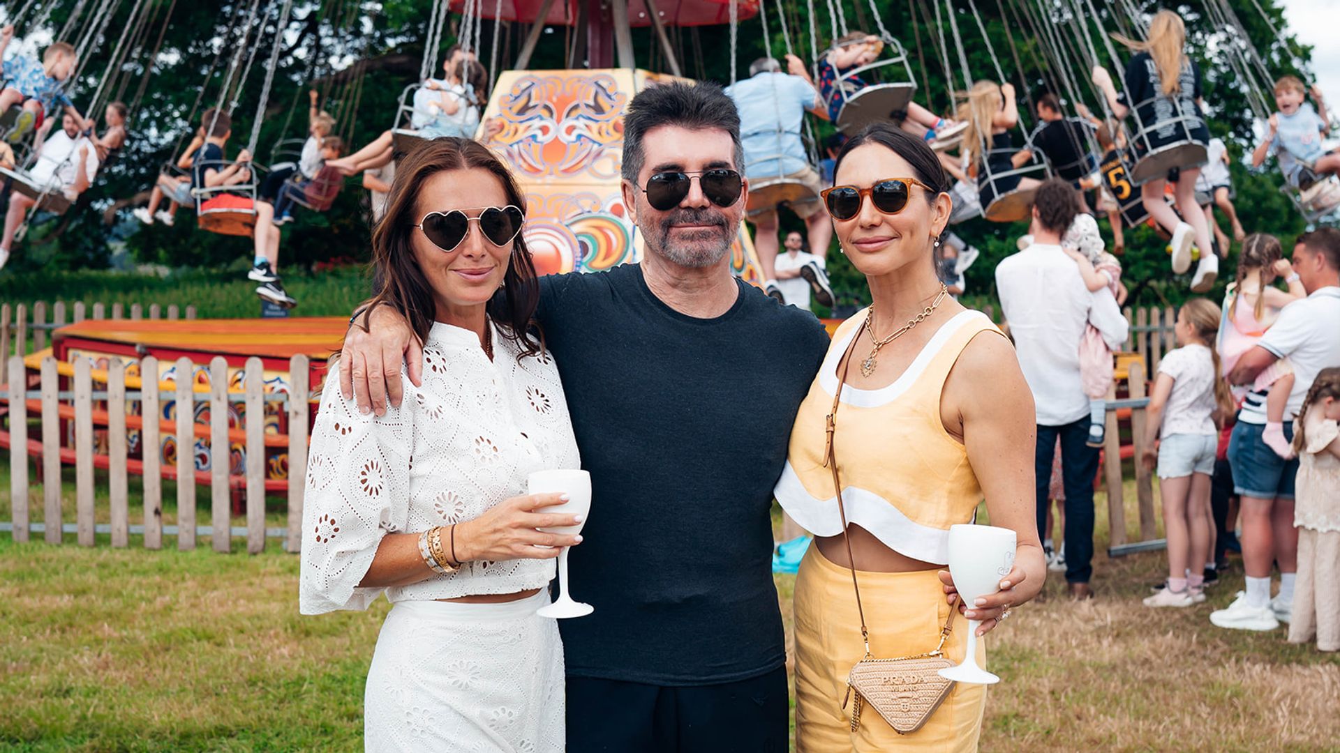 Simon Cowell and Lauren Silverman in front of a fair ground ride