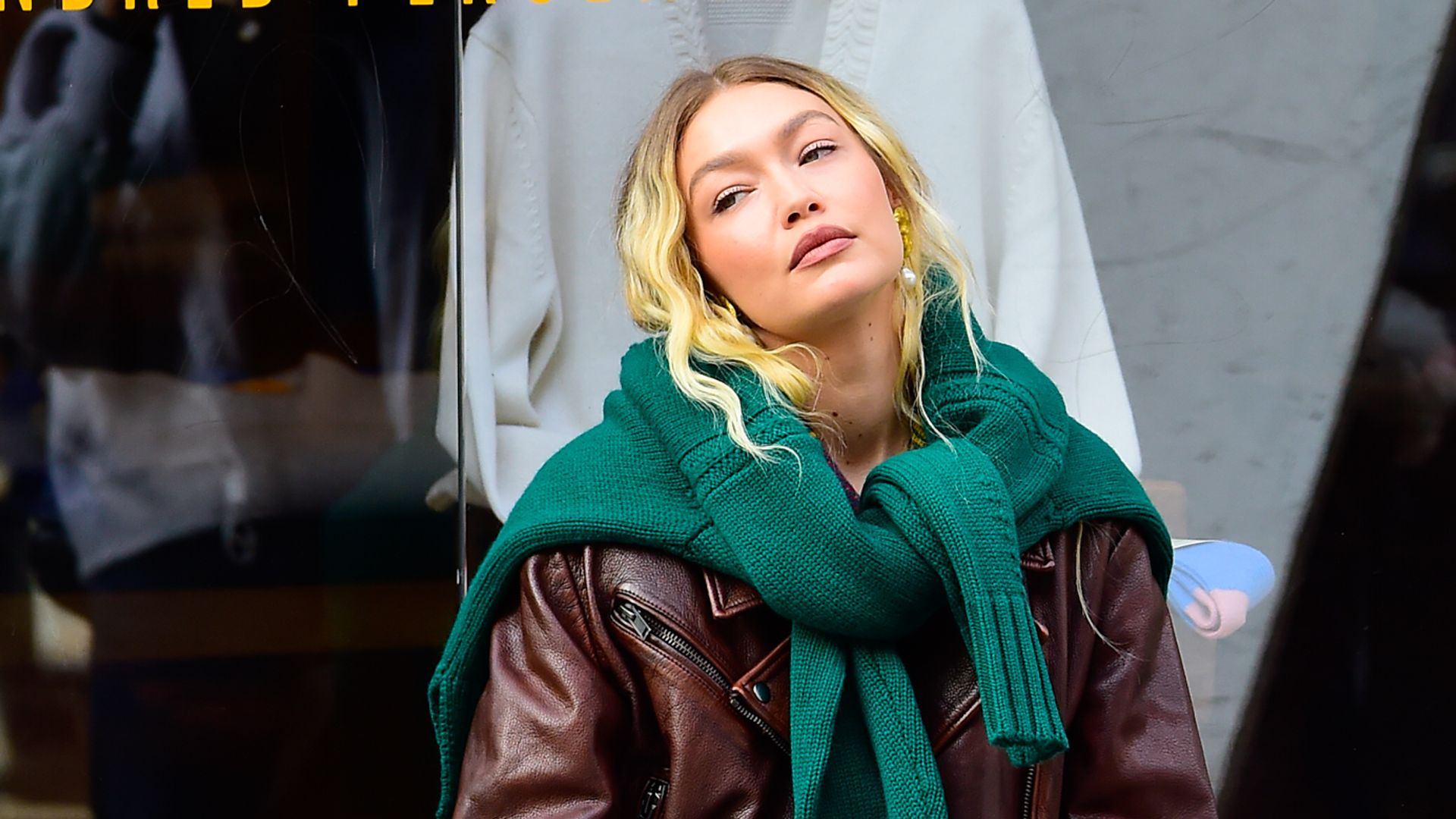  Gigi Hadid is seen at photoshoot in NYC wearing a green knit, brown leather jacket, whiote trousers and sneakers
