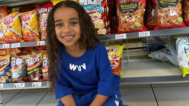 Dream Kardashian crouching on the floor in the supermarket