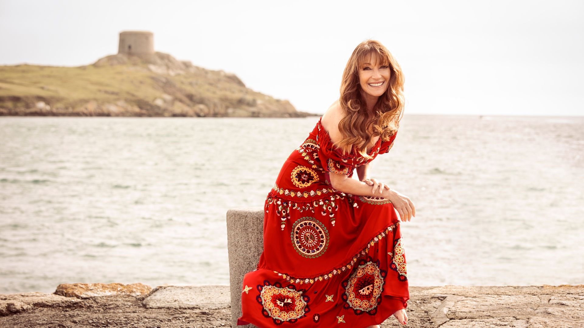 Jane Seymour looks gorgeous in red strapless summer dress for Monsoon
