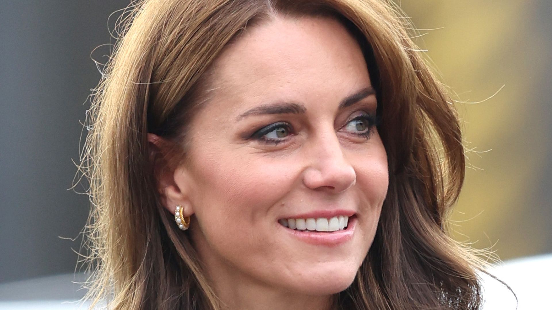 Kate Middleton with bouncy hair and gold pearl earrings at AW Hainsworth