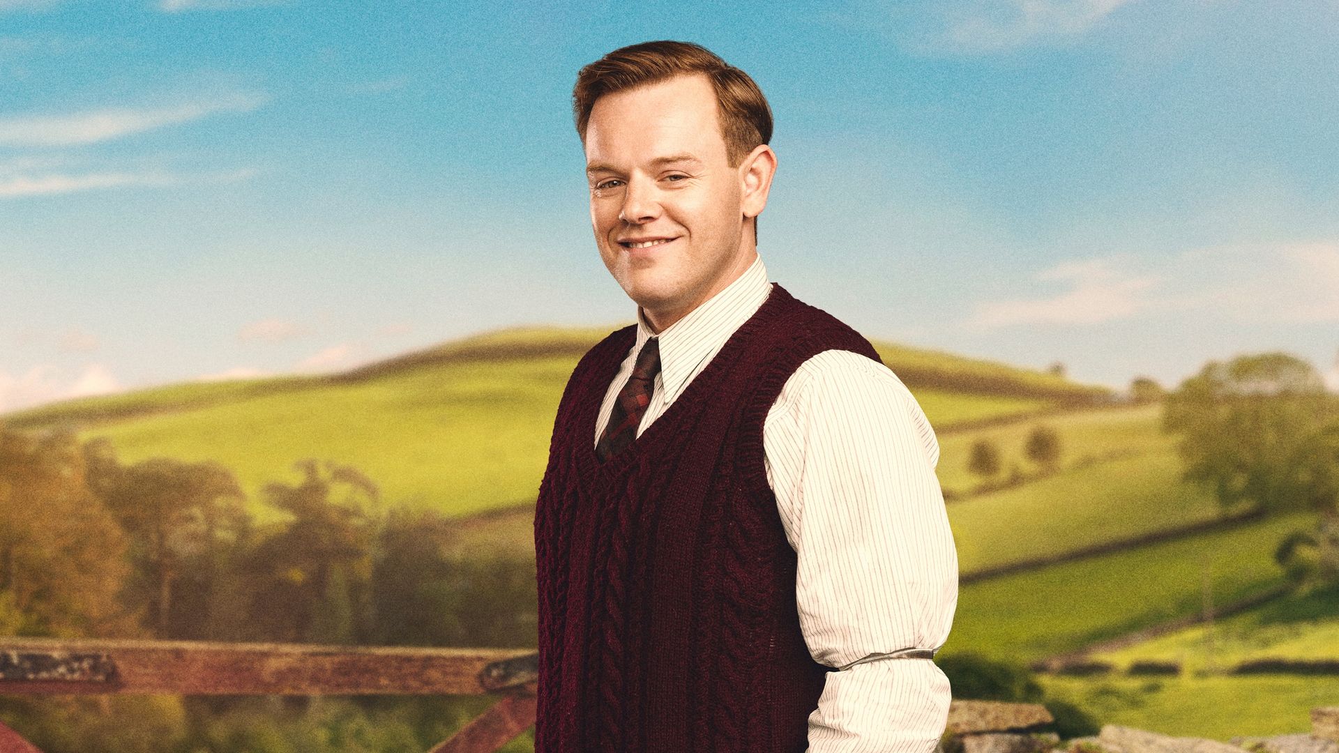 man posing for photo in front of field