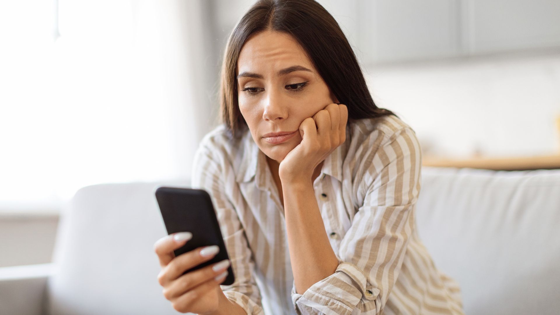 bored woman looking at mobile phone.