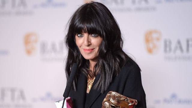 Claudia Winkleman holding award in black blazer