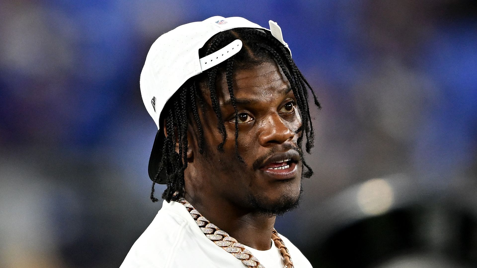 Lamar Jackson in white top and cap watching the game in the fourth quarter against the Indianapolis Colts during the NFL Preseason 