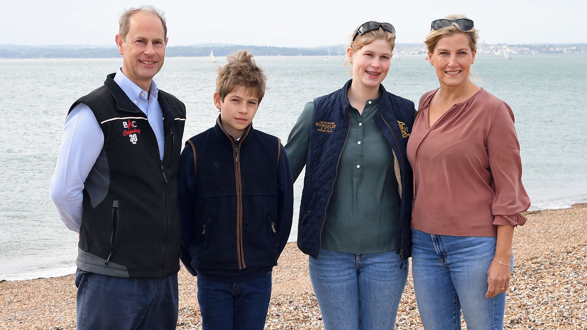 The Duke and Duchess of Edinburgh standing with their children on a beach