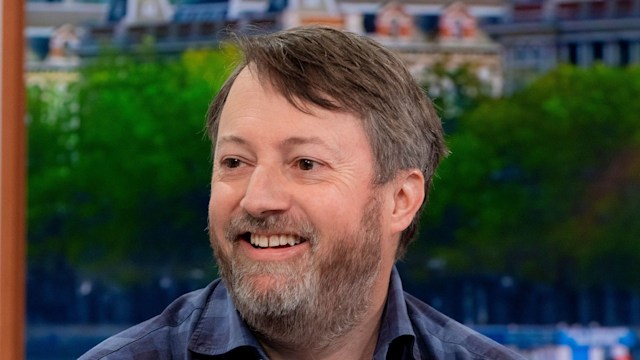 david mitchell smiling in blue check shirt