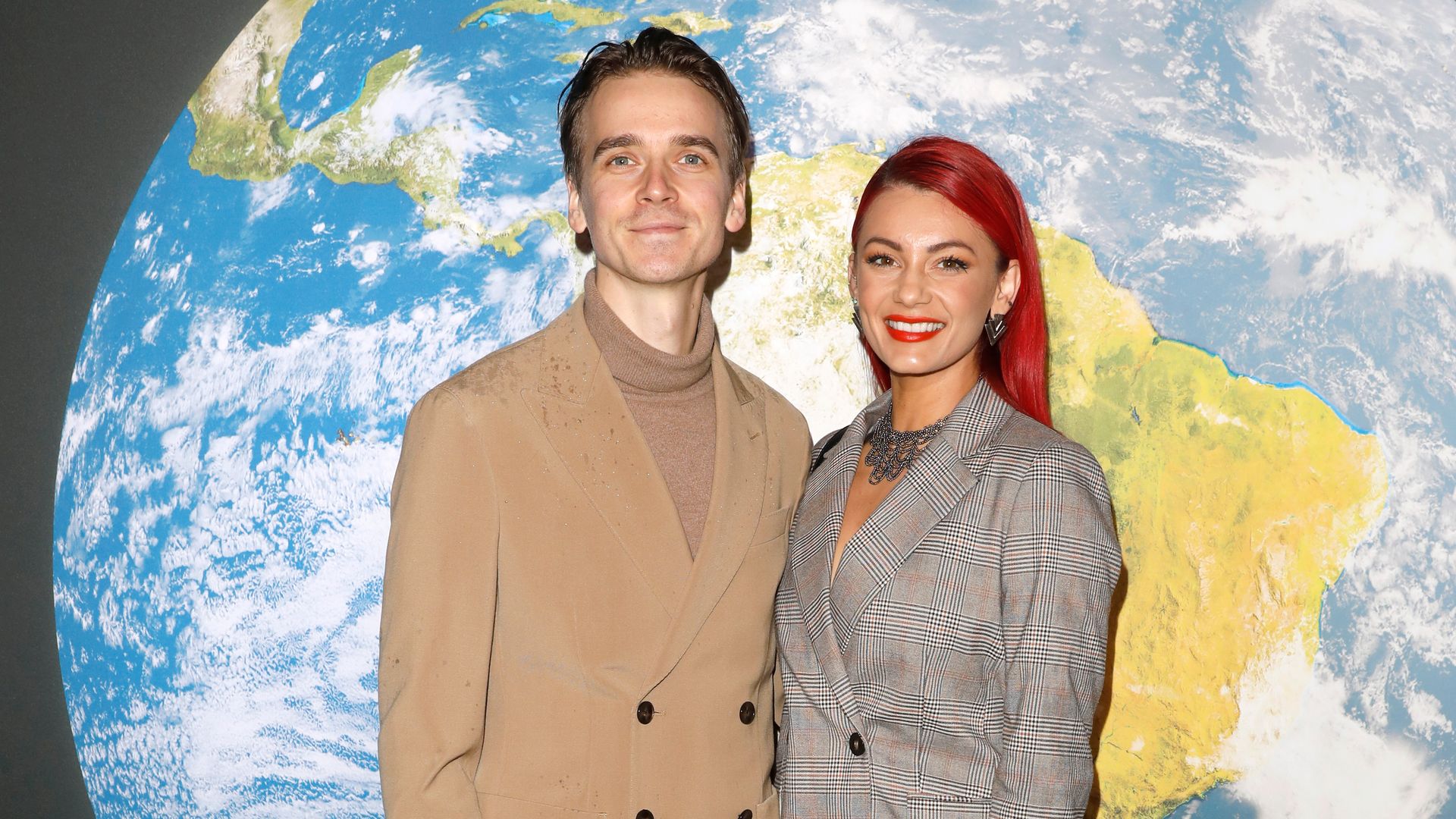 Dianne Buswell and Joe Sugg in front of a projection of Earth