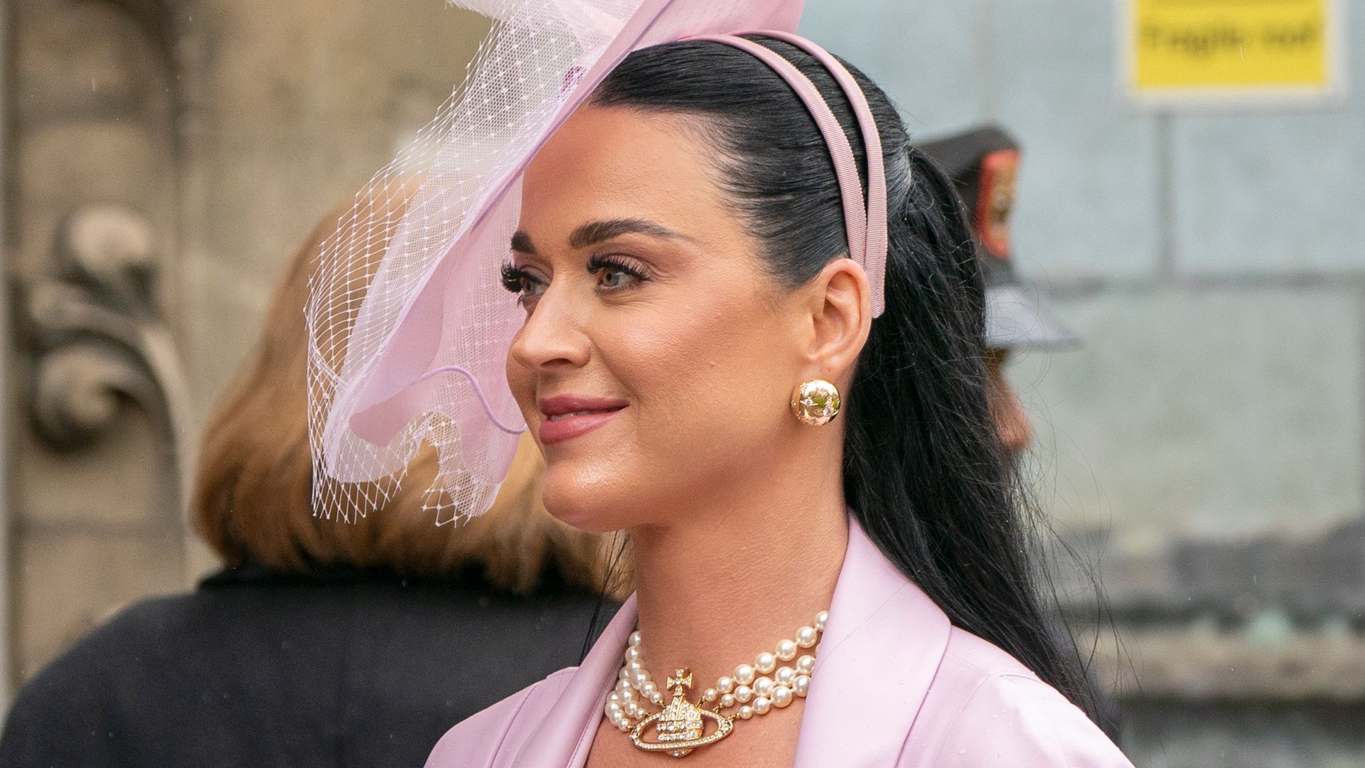Katy Perry smiles as she walks in Westminster Abbey for coronation service