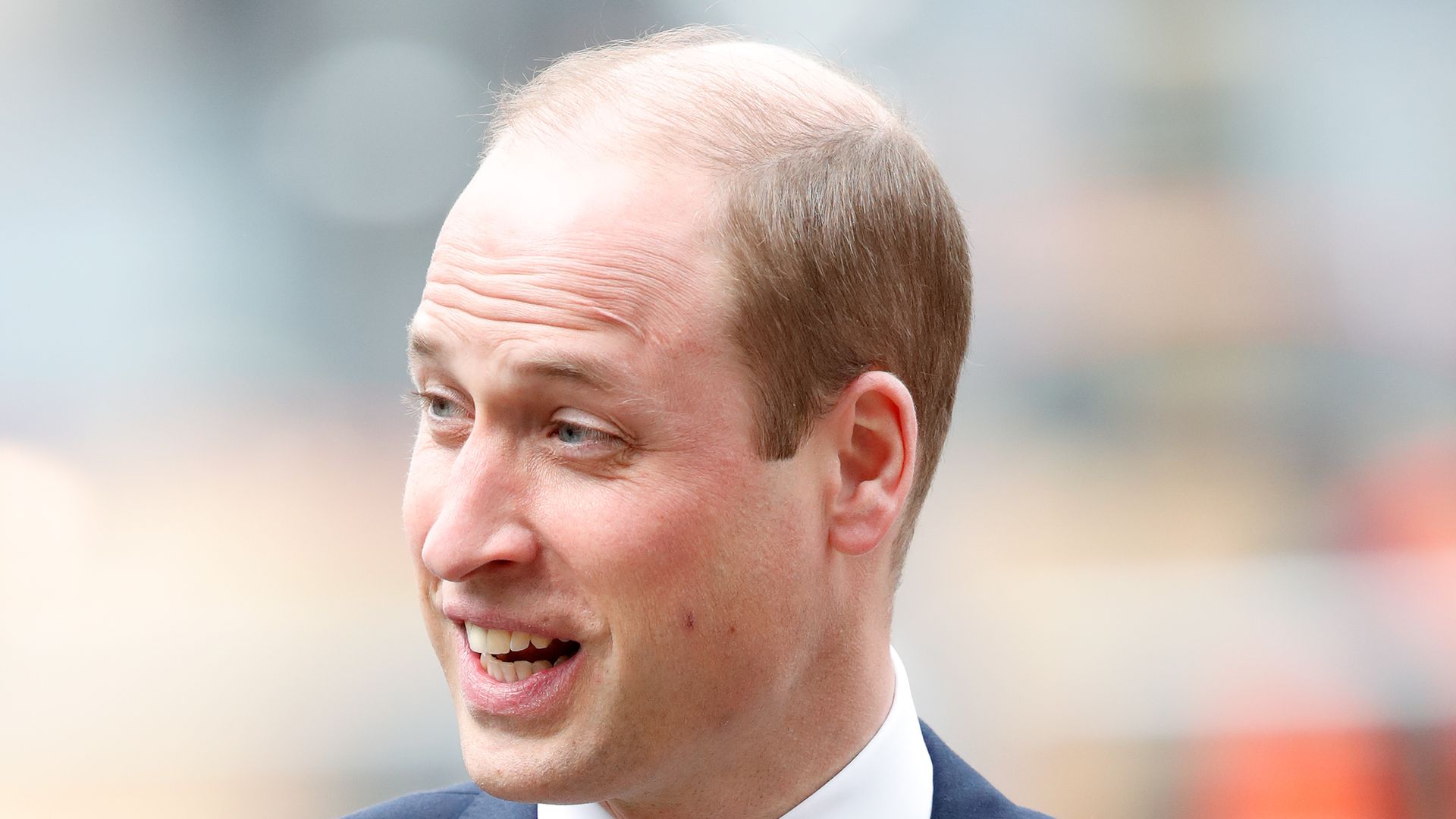 Prince William laughing in a suit