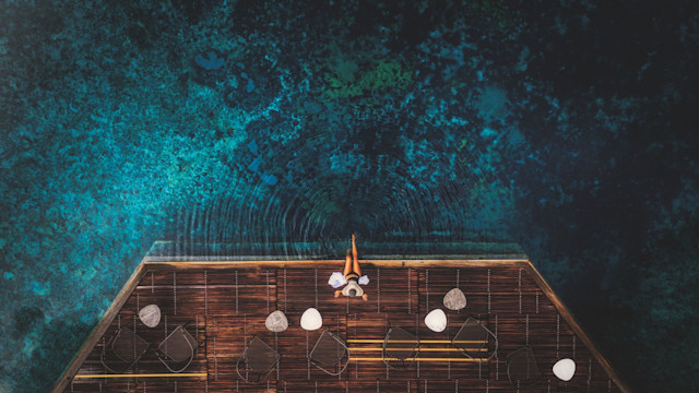 A woman posing on a deck overlooking a hot spring in the Terme di Saturnia hotel in Tuscany