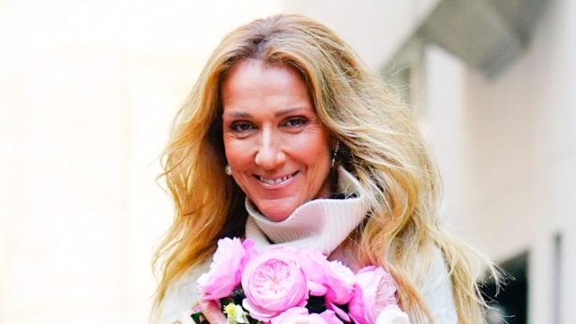 Celine Dion smiling and holding pink flowers in 2020 in NYC 