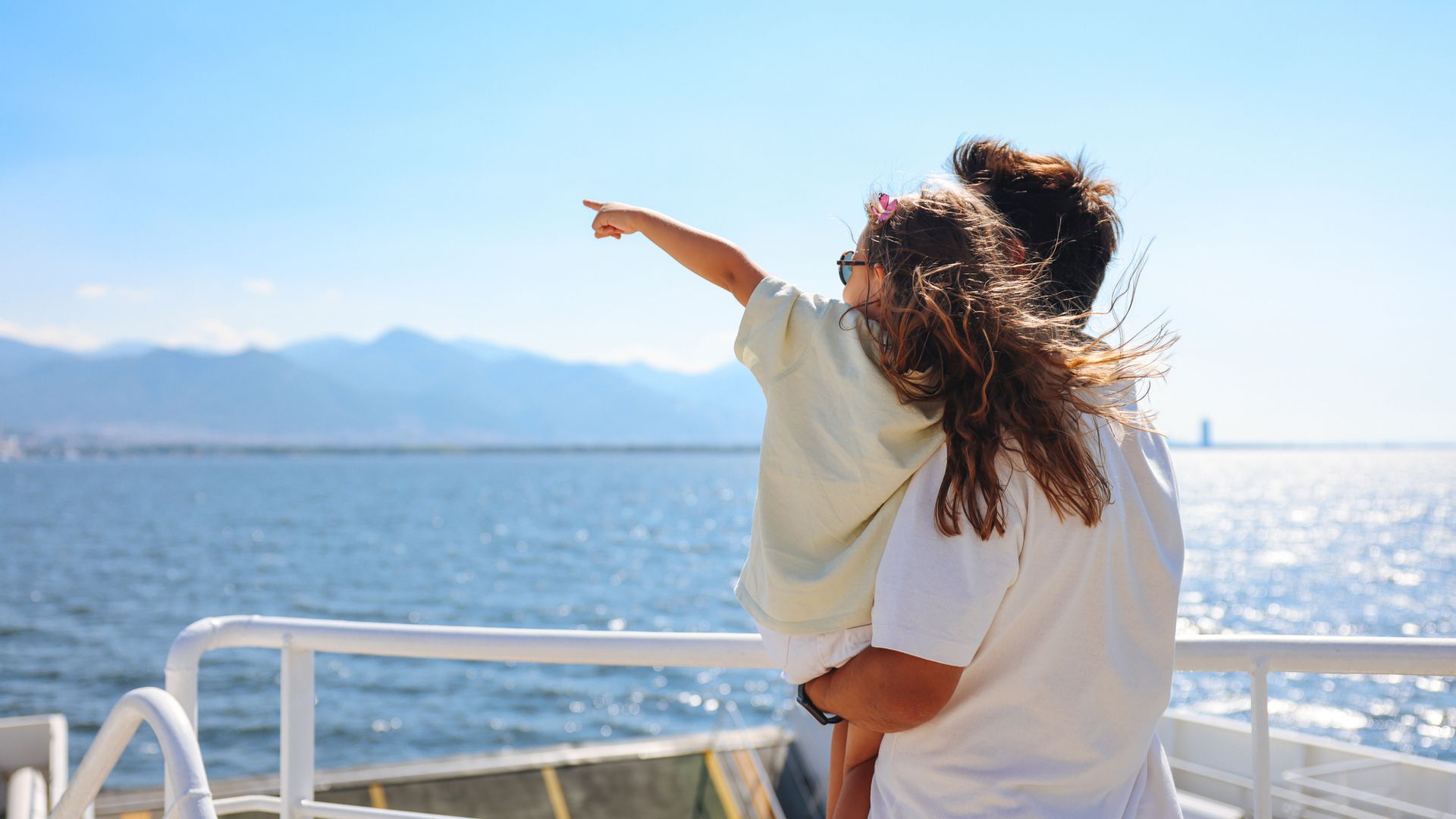 Girl traveling by ship with her father and looking seagull
