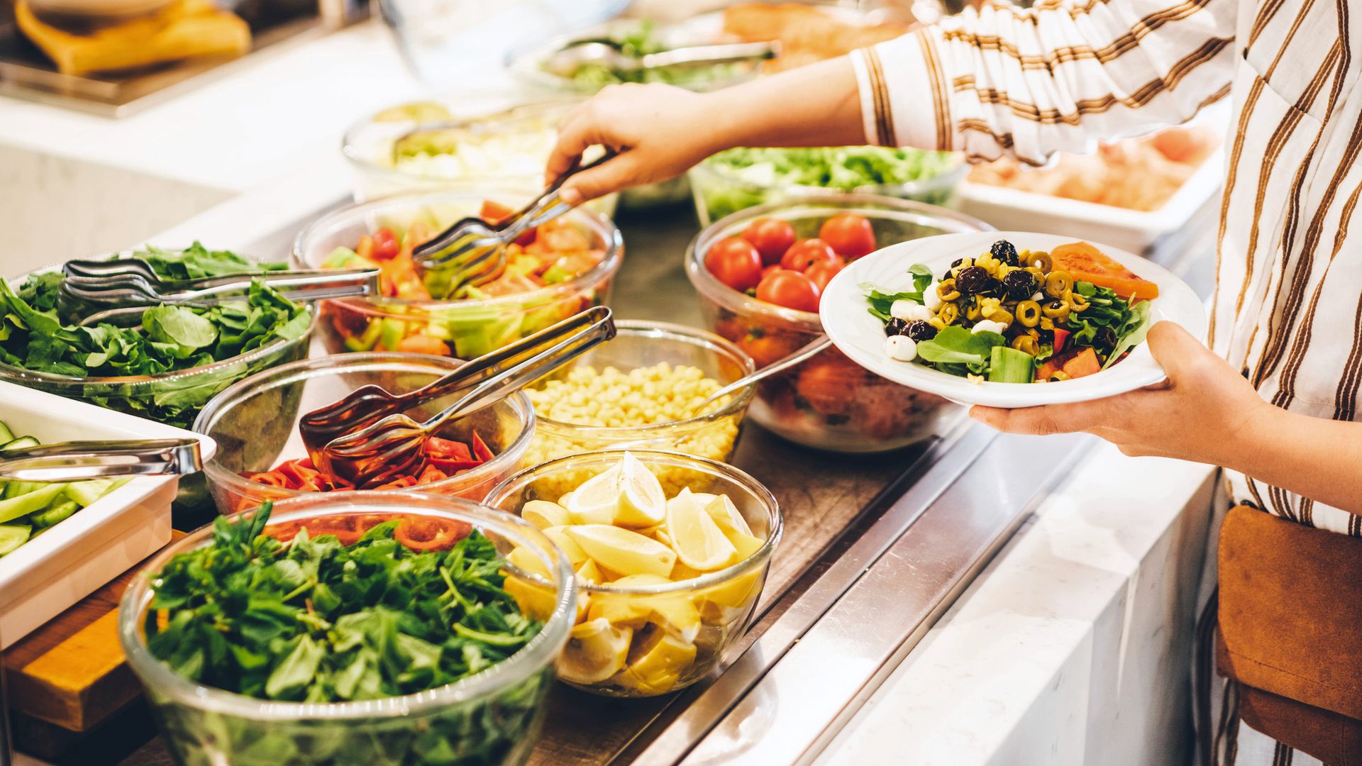 Woman choosing food for breakfast at hotel restaurant