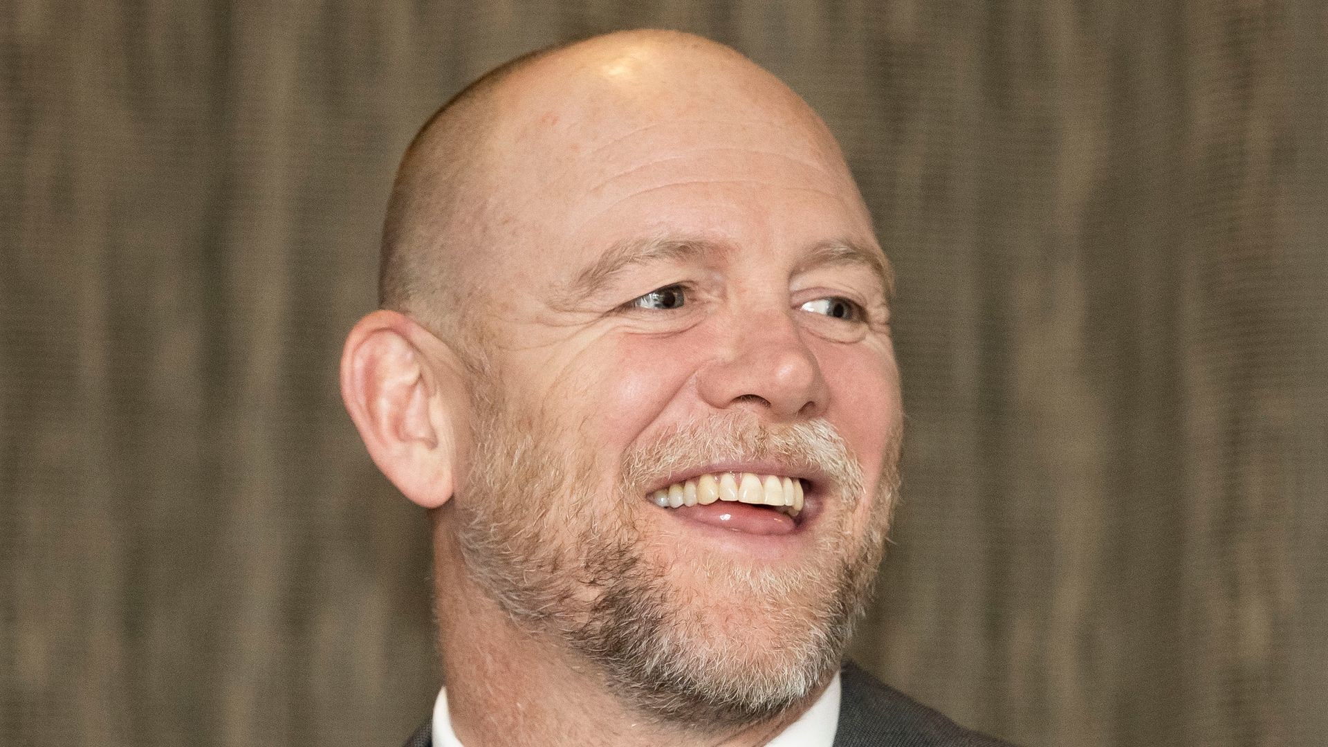 Mike Tindall smiling in a grey suit