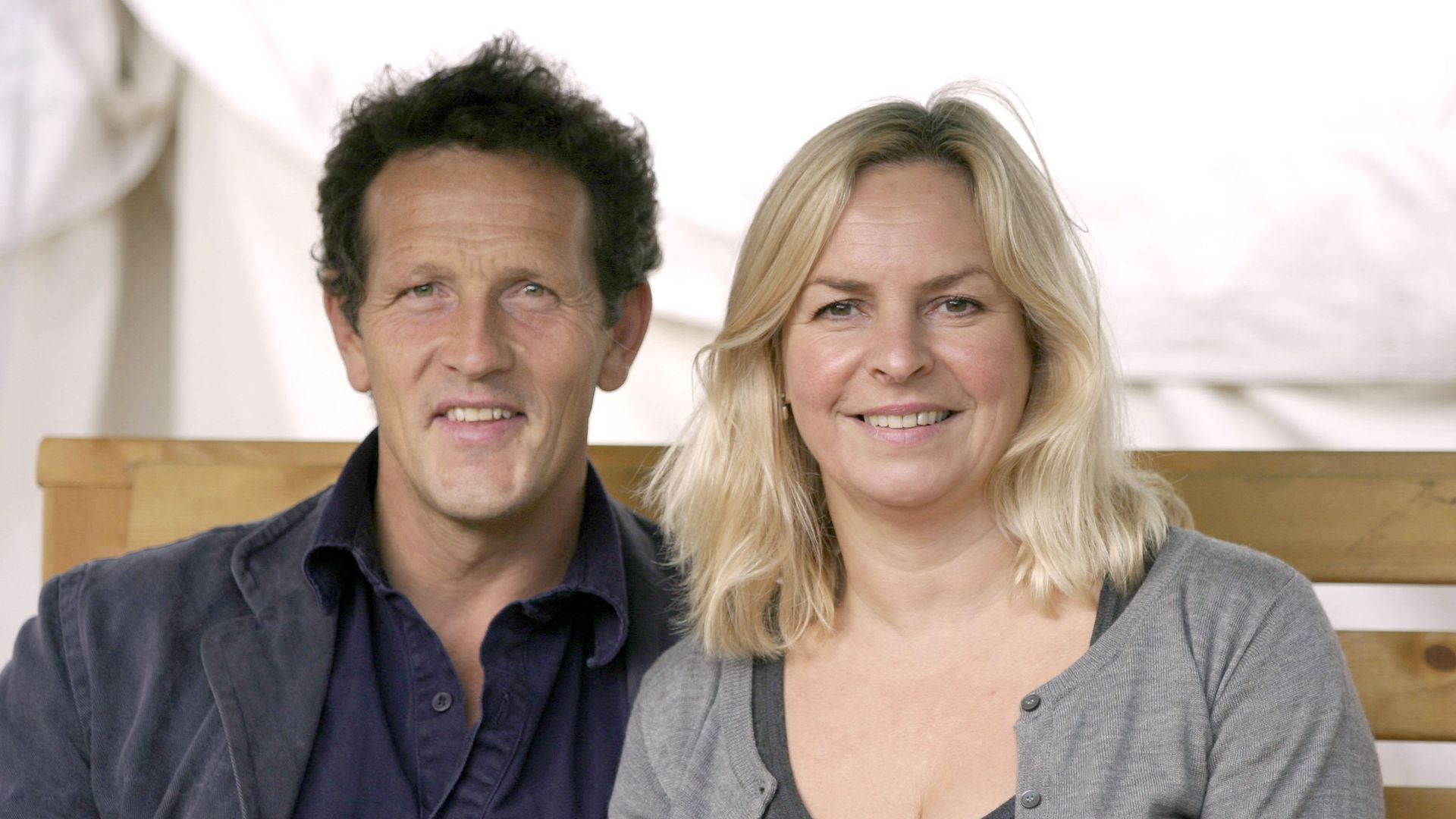 Monty Don and Sarah Don smiling sitting on a bench