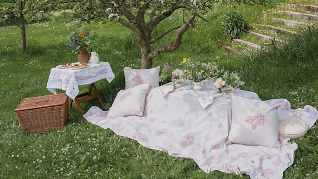 a chic picnic in a restic english garden with cushions and wild flowers by Rosanna Falconer