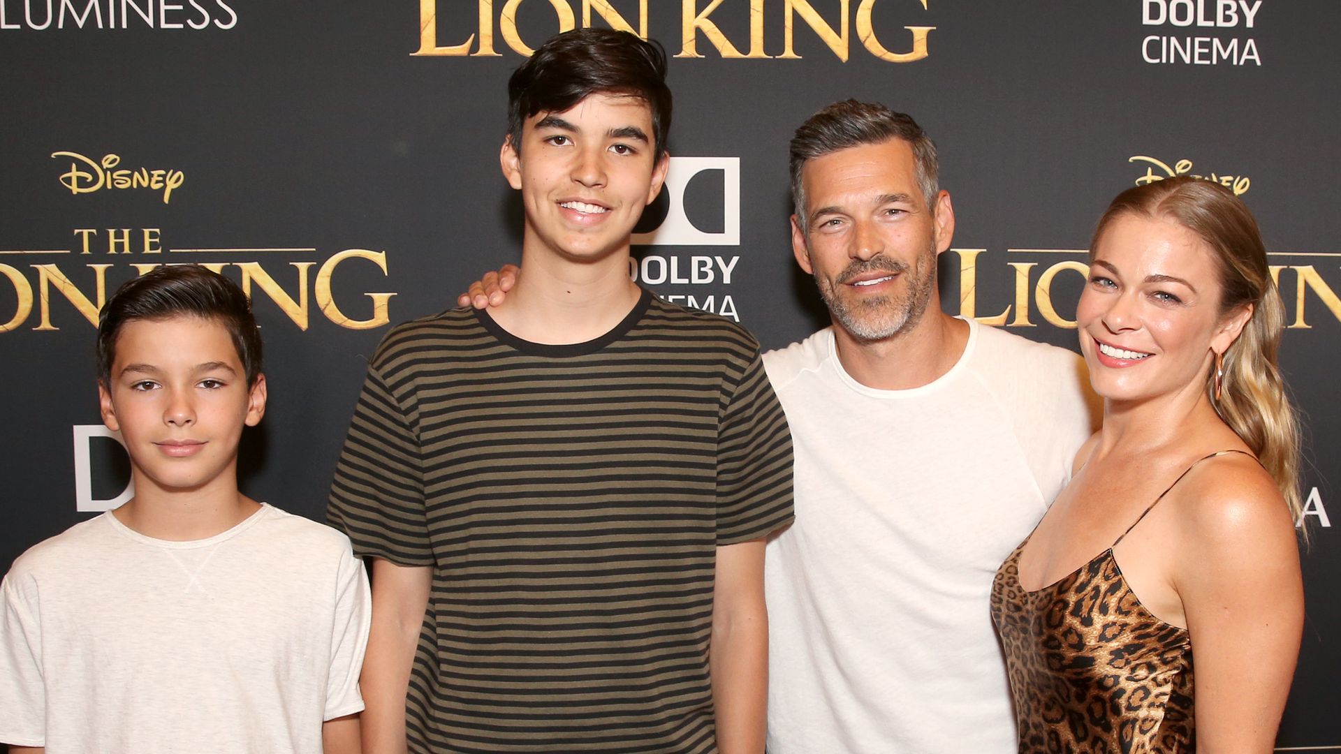 Jake Austin Cibrian, Mason Edward Cibrian, Eddie Cibrian, and LeAnn Rimes against lion king backdrop