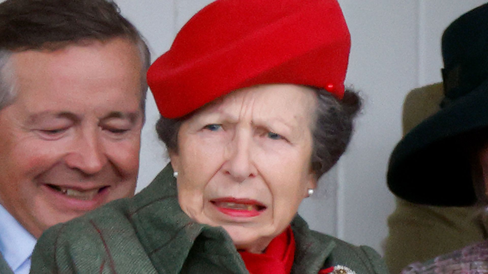 Princess Anne in a red beret pulling a face
