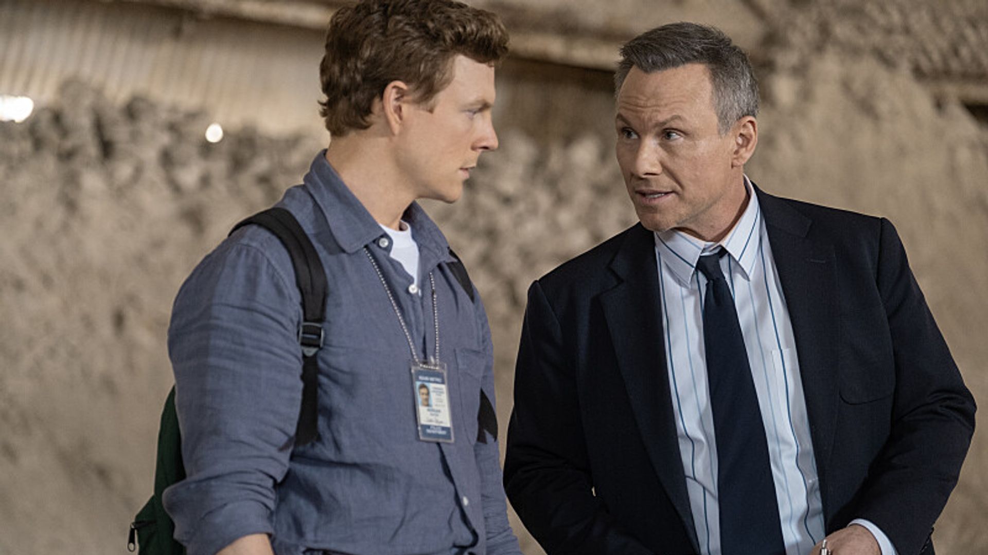 younger man and older man in suit standing outdoors