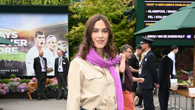 Alexa Chung wearing a beige shirt, straight-leg jeans and glossy mules 