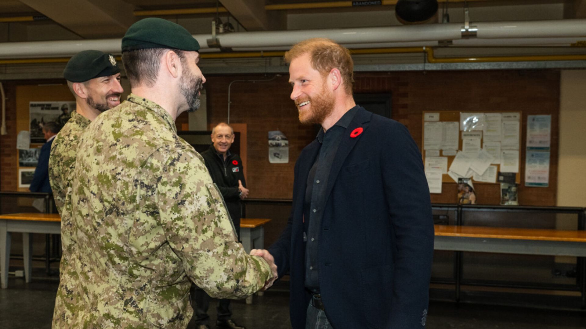 Prince Harry shaking hands with a man in military uniform